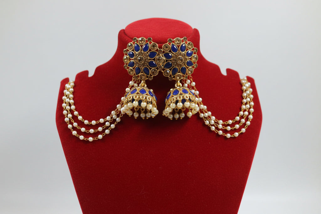 Gold-toned traditional Indian jhumka earrings with deep blue stone inlay and a matching pearl-beaded choker necklace, displayed on a white jewelry bust.