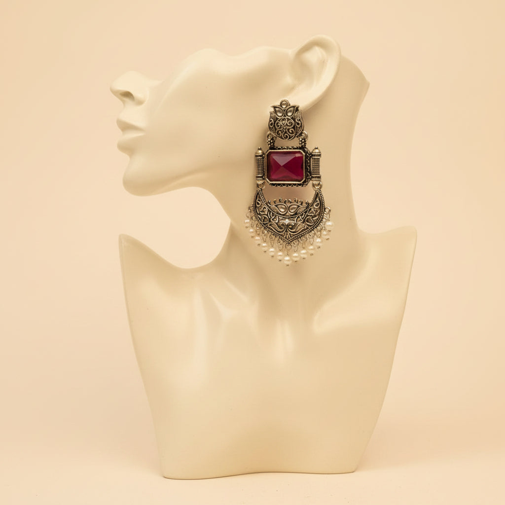 A pair of silver-toned traditional Indian chandelier earrings with rectangular pink gemstones and white pearl bead fringe, displayed on a white card labeled 'Fashion Jewellery'.