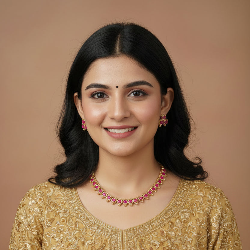 Gold-tone jewelry set featuring a necklace and matching earrings with pink heart-shaped stones, displayed on a black velvet jewelry bust.