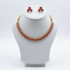 Gold-tone jewelry set featuring a necklace and matching earrings with pink heart-shaped stones, displayed on a black velvet jewelry bust.