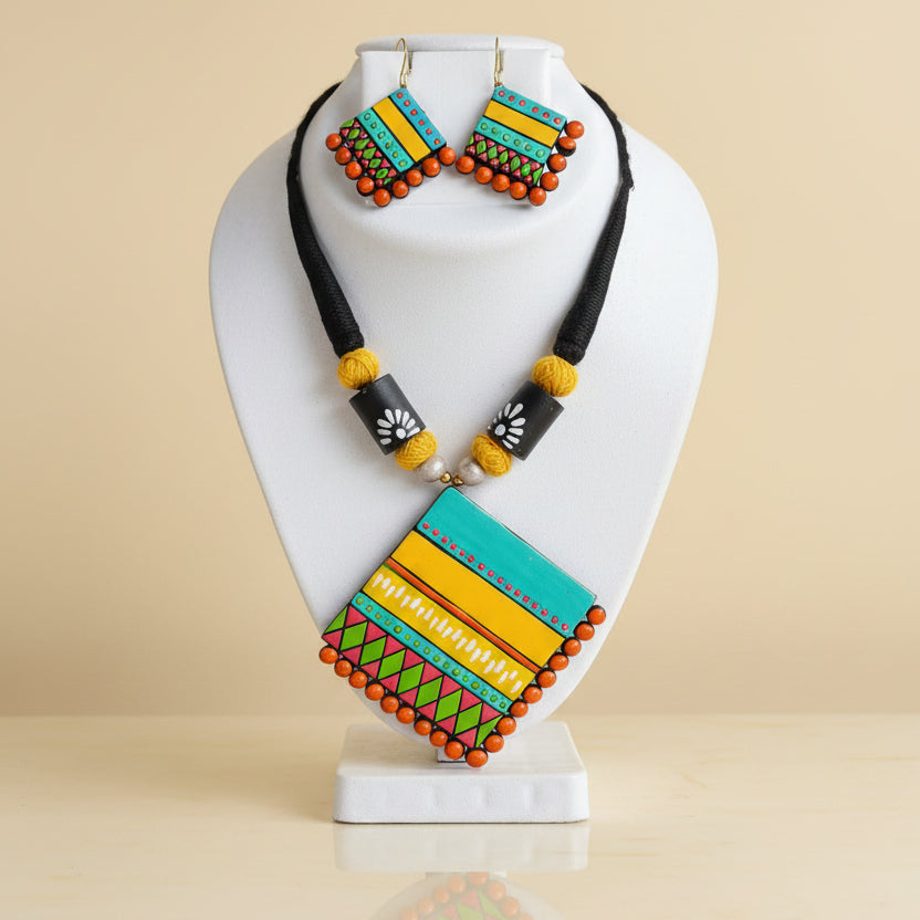 A handcrafted Terracotta Multicolour Statement Necklace Set in blue, yellow, and green tones, displayed with matching earrings.