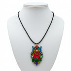 Handpainted terracotta owl pendant necklace on a black cord, displayed on a white bust